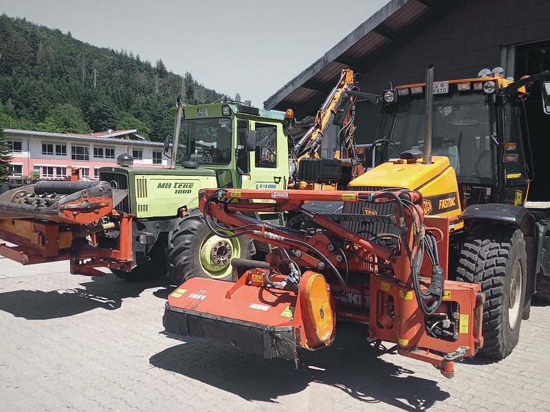 Fuhrpark mit Mulchgeräten vor der Werkhalle